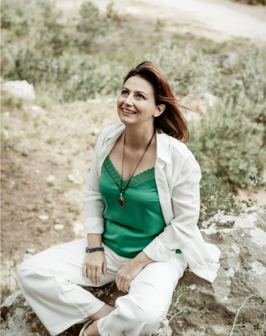 Alice Hoareau assise dans l'herbe et regardant le ciel avec un sourire